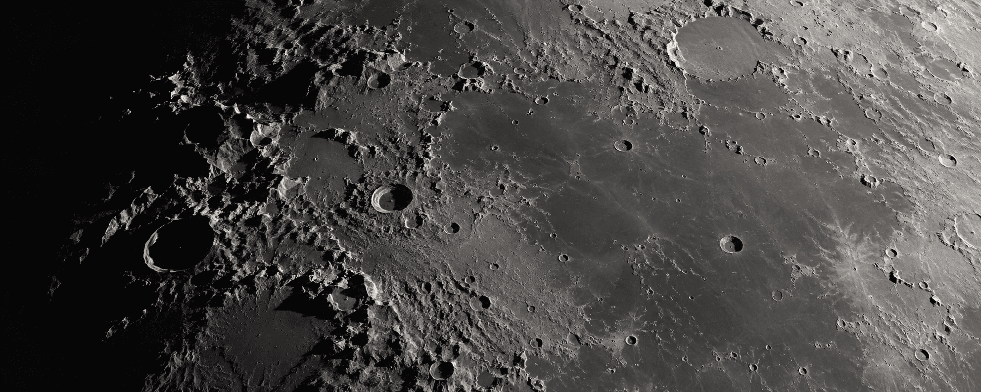 AI-generated preview. A panoramic grayscale study of cratered lunar terrain and raking shadows. Not a telescope capture.